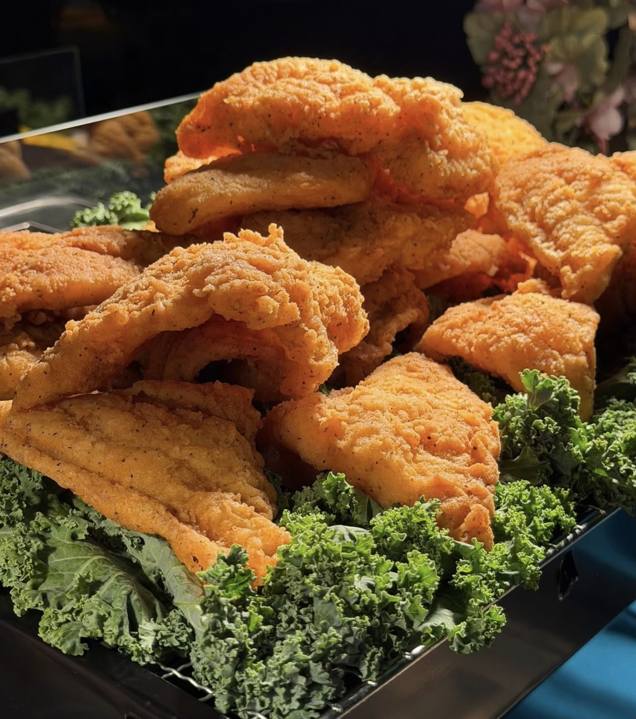 Golden fried fish fillets served on fresh kale